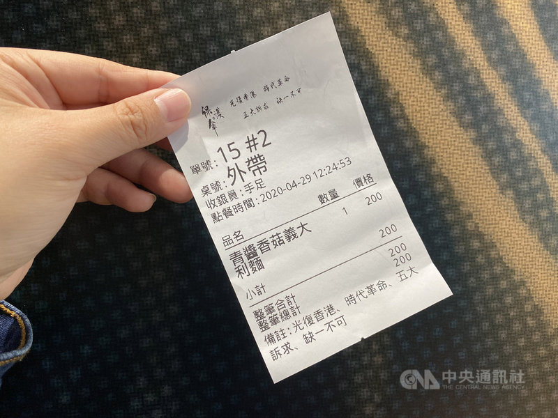 位於台北的「保護傘」餐廳,店內裝潢充滿「反送中」元素,取餐單的備註也印上「光復香港、時代革命、五大訴求、缺一不可」標語;收銀員則統稱「手足」。中央社記者賴言曦攝 109年4月29日