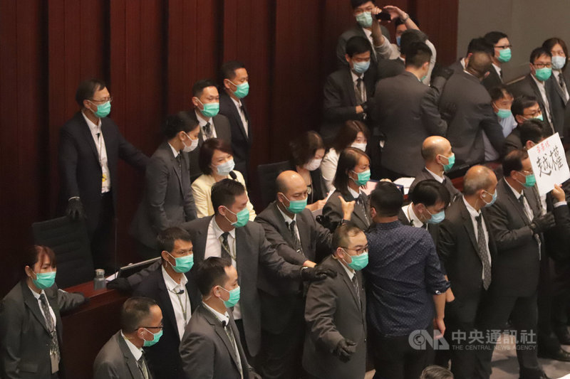 香港立法會內委會8日首次由建制派議員李慧琼（穿黃衣者）主持會議，泛民議員不滿並阻撓會議進行。圖為李慧琼在大批保安守護下主持會議。中央社記者張謙香港攝　109年5月8日