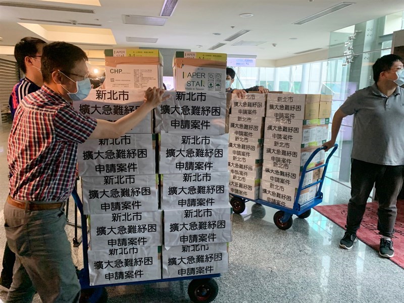 配合中央對擴大急難紓困申請簡化作業的最新指示「地方政府快速收件、中央審核、基層免責」,新北市政府8日將29區公所2天來所完成受理的民眾申請案共9301件裝箱,由專人送至衛生福利部核定。中央社記者葉臻攝 109年5月8日