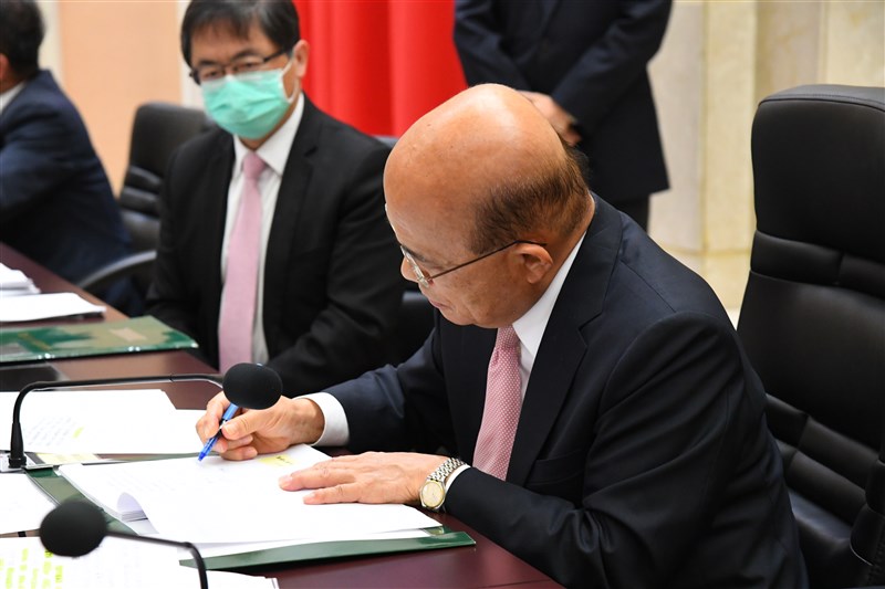 行政院長蘇貞昌(前)14日在所有內閣成員依序在總辭公文上簽名或蓋章後,批示簽呈文稿,完成總辭程序。(行政院提供)