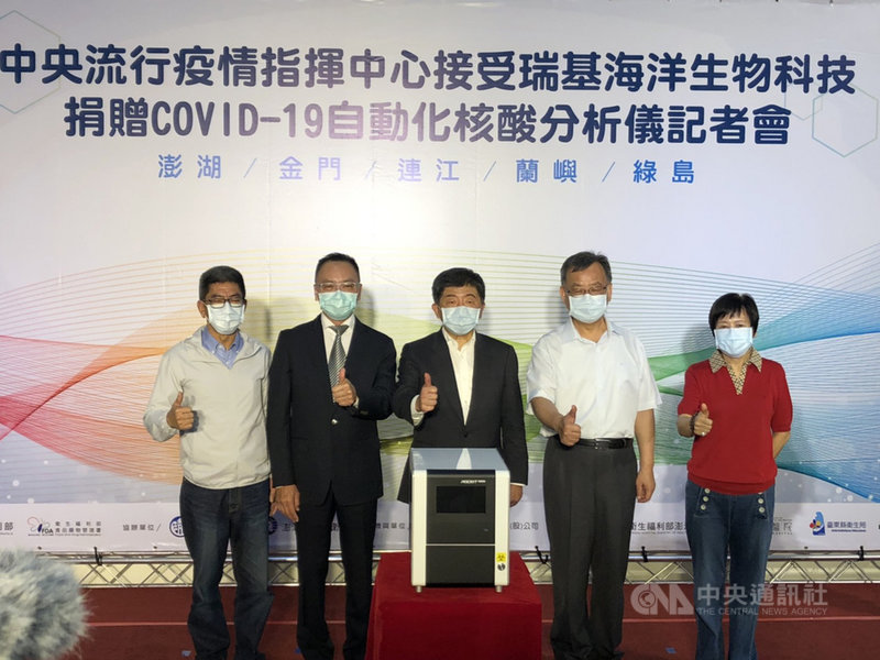 中央流行疫情指揮中心指揮官陳時中(中)22日到澎湖縣,代表接受業者捐贈武漢肺炎檢測儀器給澎湖、金門縣、連江縣、台東縣蘭嶼鄉與綠島鄉,檢測時間約85分鐘,讓離島民眾能安心。圖右2為澎湖縣長賴峰偉。(食藥署提供)中央社記者張茗喧傳真 109年5月22日