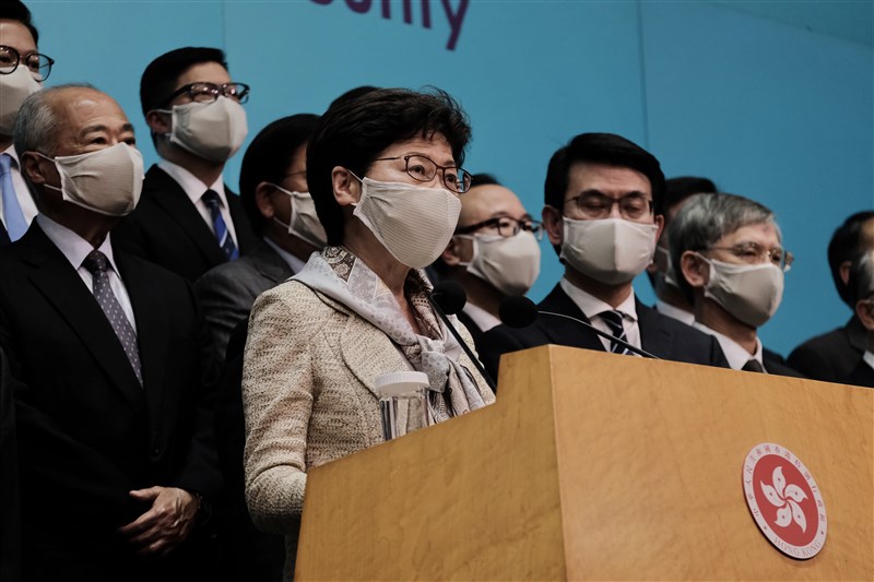 香港行政長官林鄭月娥(前)22日從北京返港,率領政務官員、行政會議成員會見記者說明法案事由。(中新社提供)