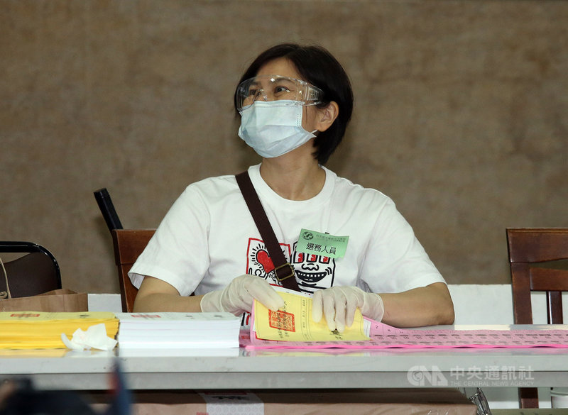 民進黨24日舉行地方黨部主委、縣市黨代表及全國黨代表選舉,投票所嚴格執行防疫規定,除測量體溫、戴口罩等,選務人員還戴上護目鏡及手套。中央社記者郭日曉攝 109年5月24日