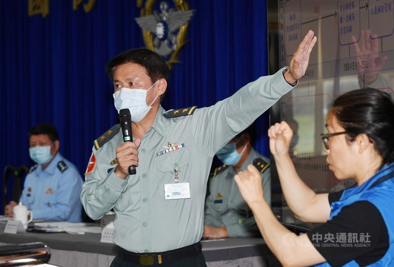 國防部總督察長黃國明(前右2)26日下午在記者會中,公開說明海軍109年敦睦艦隊官兵染疫調查最新進度,指出預計本週前將全數完成人員訪談,勾稽比對;會中並首度邀請手語老師協助翻譯。中央社記者施宗暉攝 109年5月26日