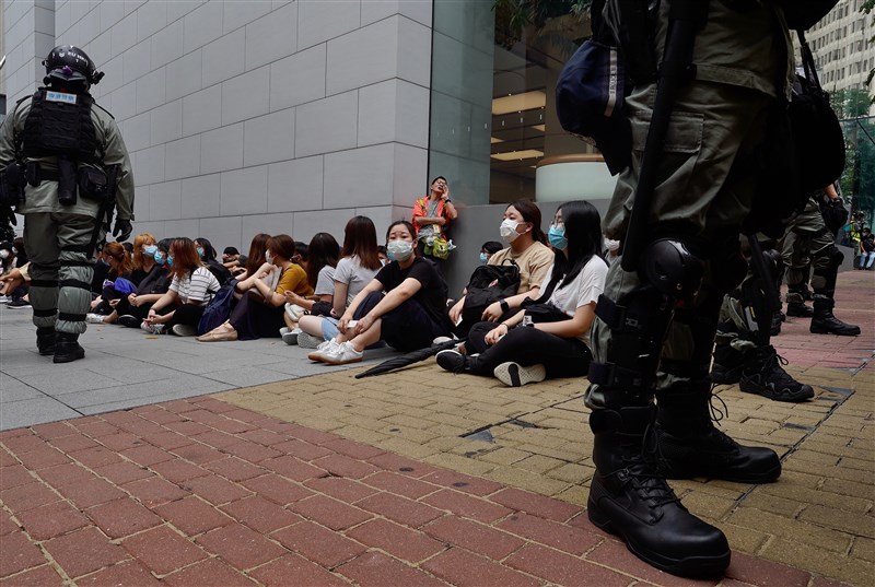 圖為香港立法會27日恢復二讀辯論「國歌條例草案」,民眾包圍議會抗議遭港警逮捕。(美聯社)