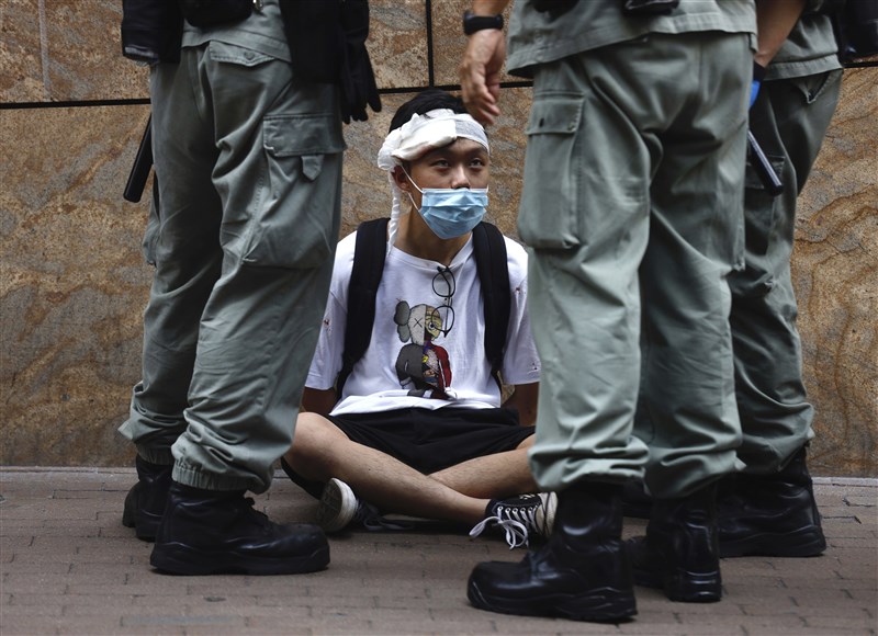 中國企圖推「港版國安法」引發高度爭議,美國國務卿蓬佩奧27日向美國國會認證,香港不再擁有高度自治,因此不再符合美國法律下特殊待遇。圖為香港立法會27日恢復二讀辯論「國歌條例草案」,港警與議會外抗議民眾對峙。(美聯社)