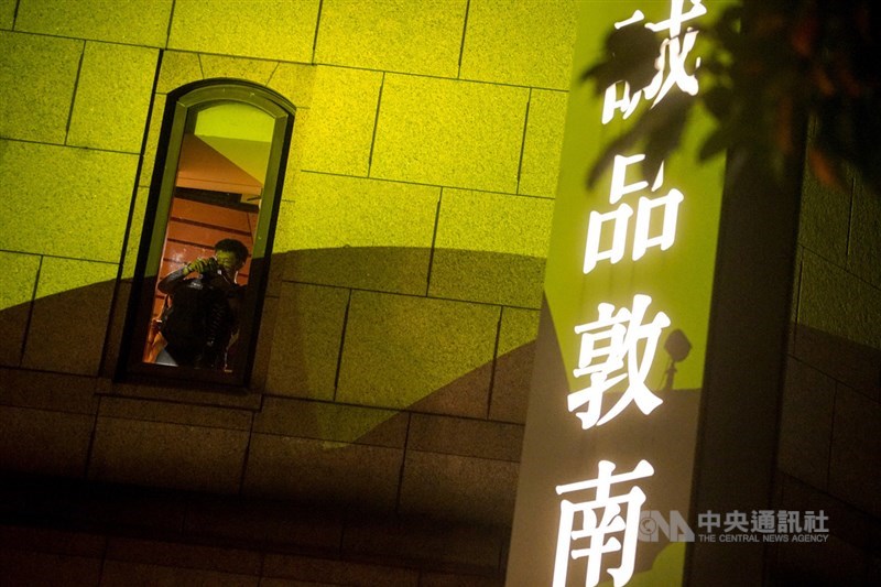 「不打烊書店」誠品敦南店吹熄燈號,31日晚間邀請歌手與樂團在1樓戶外廣場接力開唱,書店內也有民眾在窗口觀看演出。中央社記者裴禛攝 109年5月31日
