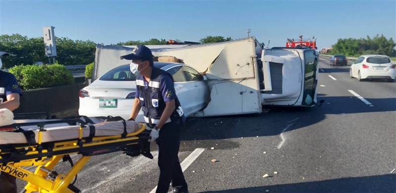 國道1號南下268公里處1日上午發生車禍,一輛貨車在快車道翻覆,後方一台特斯拉剎車不及直接撞進貨車車廂,幸無人傷亡。(嘉義縣消防局提供)中央社記者蔡智明傳真 109年6月1日