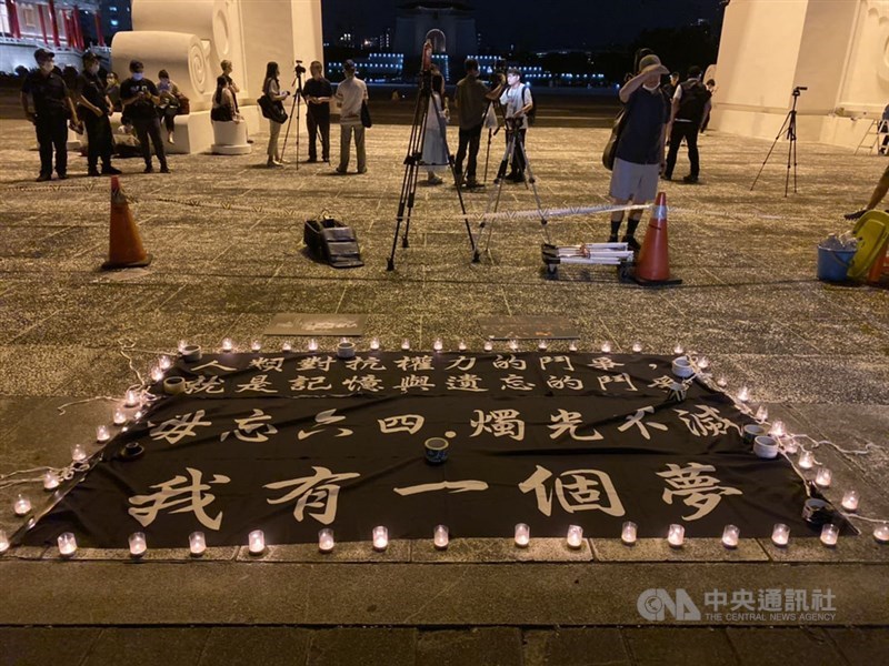 4日晚間在台北自由廣場舉行的悼念「六四」活動,現場地板鋪上寫有「人類對抗權力的鬥爭,就是記憶與遺忘的鬥爭」,「毋忘六四,燭光不滅」,「我有一個夢」的黑底白字布條。布條旁燭光環繞。中央社記者賴言曦攝 109年6月4日