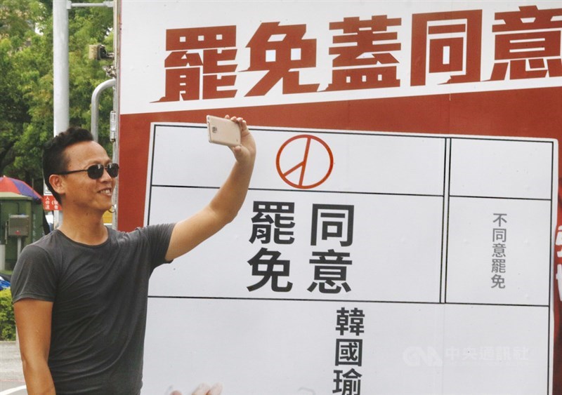 台灣自治史上頭一遭,高雄市長罷免案6日即將投、開票,高雄街頭罷韓團體5日出動宣傳車全力催票,有民眾把握機會在車旁留下紀念照。中央社記者董俊志攝 109年6月5日