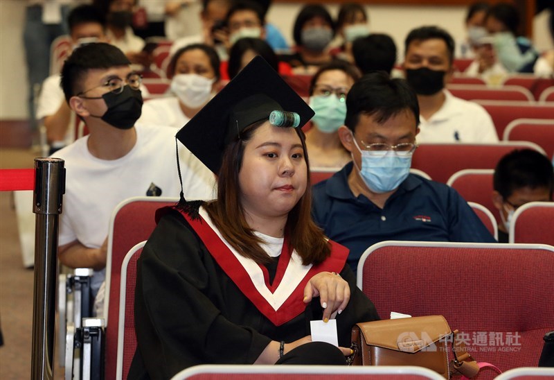為了防範疫情,參與世新大學的畢業典禮的家長都戴上口罩,畢業生為了用最佳狀態出場,則在瀏海上好髮捲等待唱名。中央社記者郭日曉攝 109年6月6日