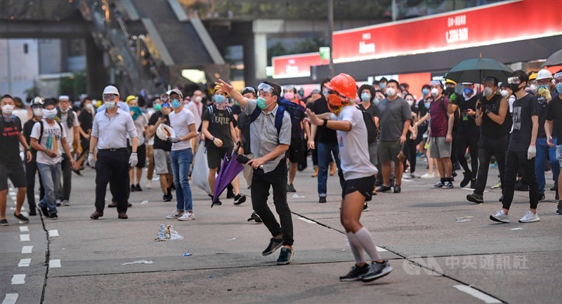 香港群眾2019年6月12日上午占據立法會周圍道路,堅定表達「反送中」立場,警方陸續投射催淚彈欲驅離人潮,抗議人士撿起催淚彈反擊。(中央社檔案照片)