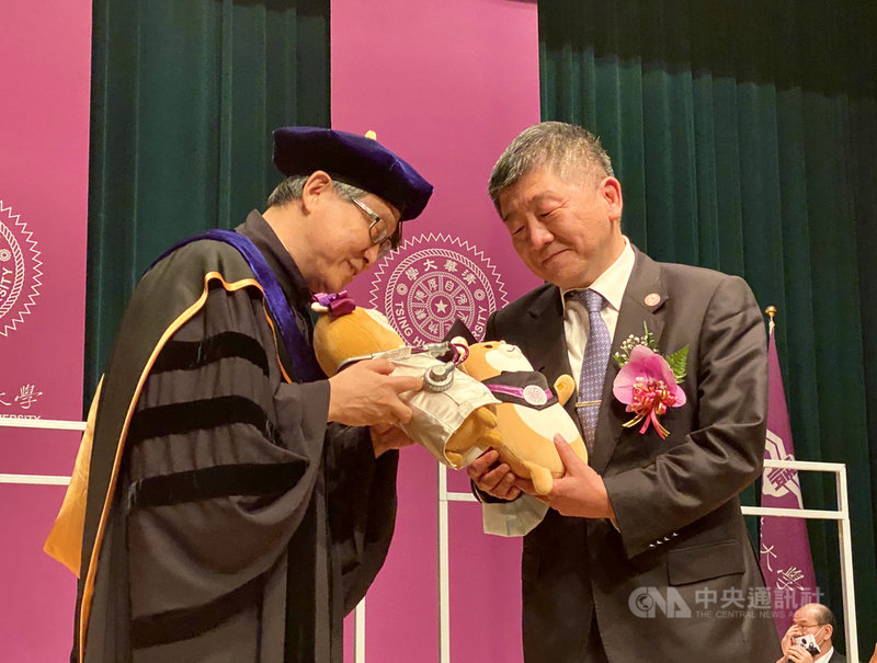 衛福部長陳時中(右)13日受邀出席國立清華大學畢業典禮,校長賀陳弘(左)致贈特製的柴犬布偶「總柴」與「總柴夫人」。中央社記者魯鋼駿攝 109年6月13日