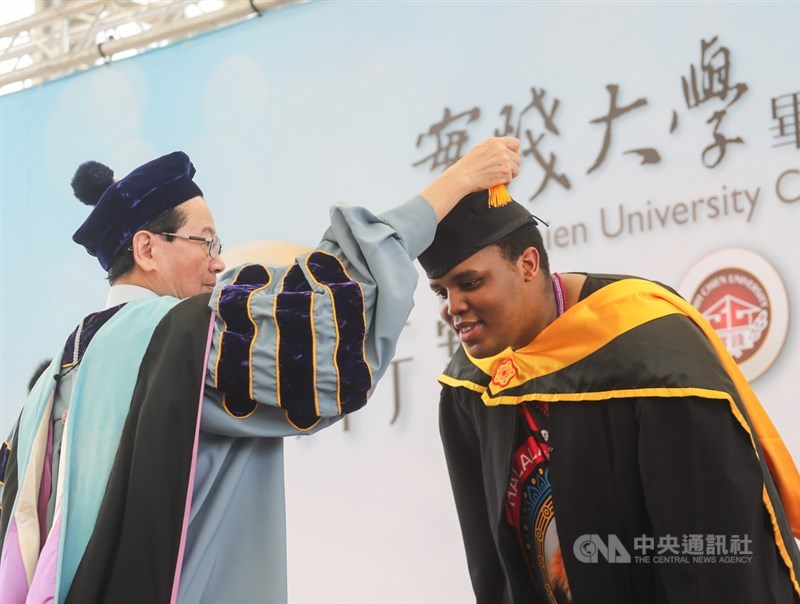 實踐大學13日在台北校區舉行畢業典禮,史瓦帝尼王國王子班柯希(Benkhosi Dlamini)(右)碩士班畢業,校長陳振貴(左)撥穗表達祝福。中央社記者裴禛攝 109年6月13日