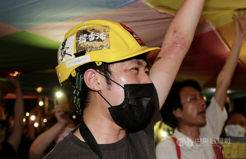 由多個民團在台發起的「抗爭未完,台港同行」反送中週年晚會,13日在台北自由廣場牌樓下舉行,活動尾聲,主辦單位邀請大家一起撐起連儂旗,象徵台灣對香港支持不間斷。中央社記者張皓安攝 109年6月13日