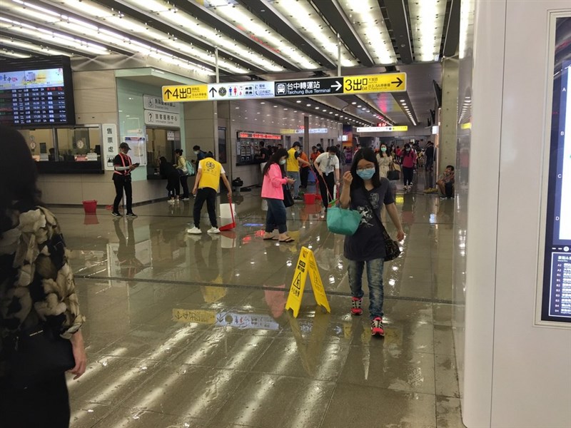 台中地區14日下午降下大雨,台鐵台中車站2樓的半露天大平台區域,因瞬間雨量無法負荷排水,大水直接灌入售票大廳,台鐵站務人員加強廣播,提醒旅客小心通過。(民眾提供)中央社記者蘇木春傳真 109年6月14日