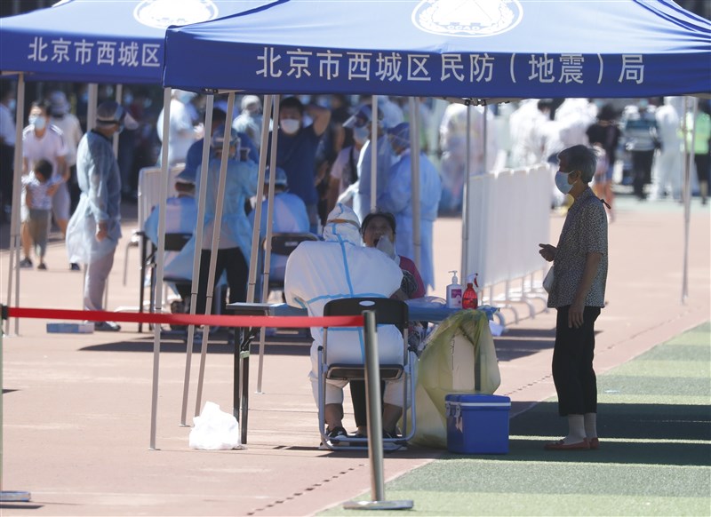 北京一名女子近日外出用餐時,接獲武漢肺炎檢測陽性的通知後情緒崩潰,隨後被送醫。圖為6月14日北京市民在一處體育場接受採檢。(中新社提供)