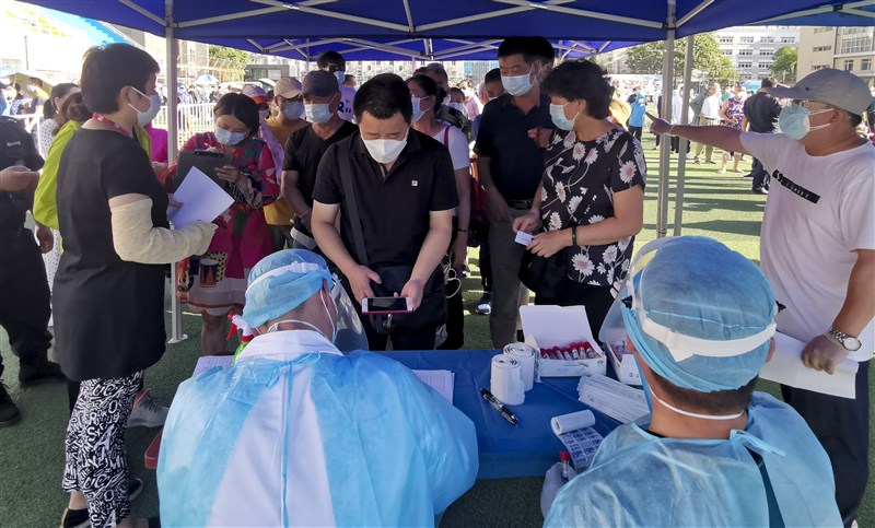 中國北京出現疫情反彈,官方也祭出嚴格防疫措施,要求新發地市場的密切接觸者14天內不得上班。圖為北京市民在體育場進行核酸採樣。(中新社提供)