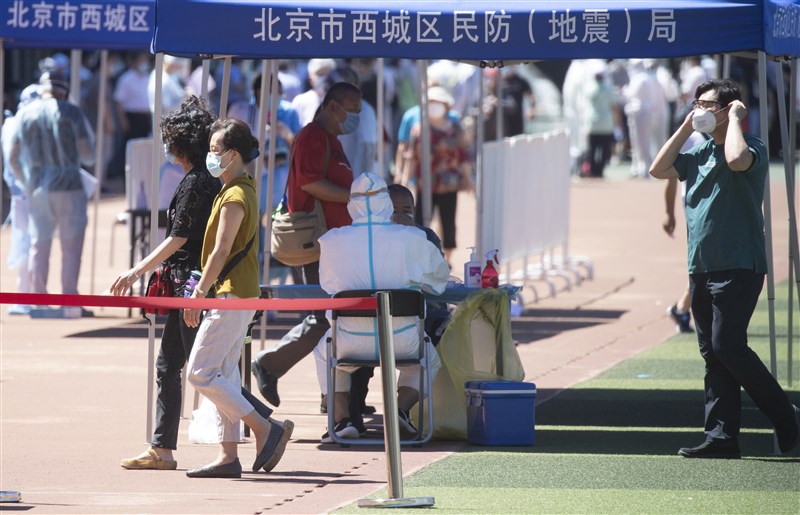 中國首都北京武漢肺炎疫情持續,14日中國新增確診共49例,其中39例為本土病例,包括北京36例、河北3例。圖為北京民眾在宣武體育場接受武漢肺炎核酸檢驗採樣。(中新社提供)