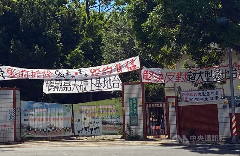 電信業者在嘉義大學民雄校區設置基台地,引起旁邊民雄農工師生不安,經協調決議6月底拆除,後因嘉大希望移置校園其他地點,農工在側門掛白布條表達不滿。中央社記者黃國芳攝 109年6月17日