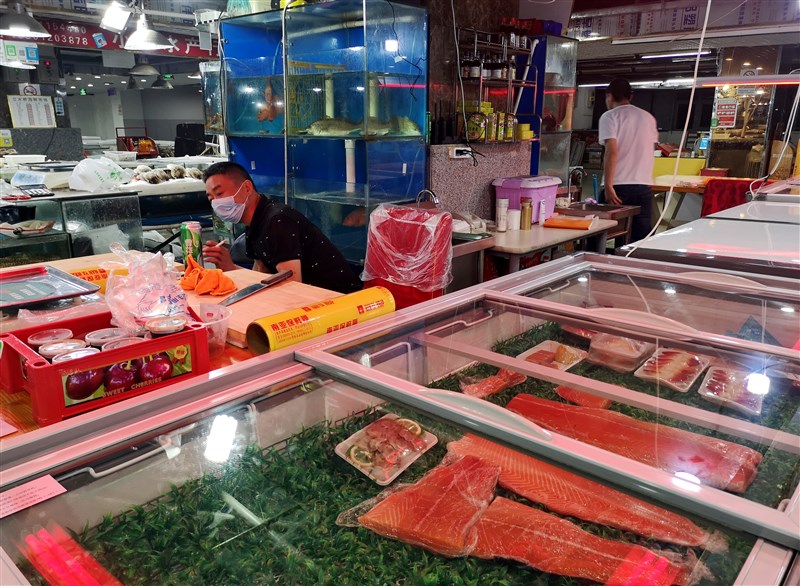 北京傳出在鮭魚砧板上驗出歐洲的武漢肺炎病毒株,病毒專家張上淳表示,病毒透過魚傳播機會小,比較可能是隱藏的確診個案造成環境汙染。圖為北京立水橋海鮮市場。(中新社提供)