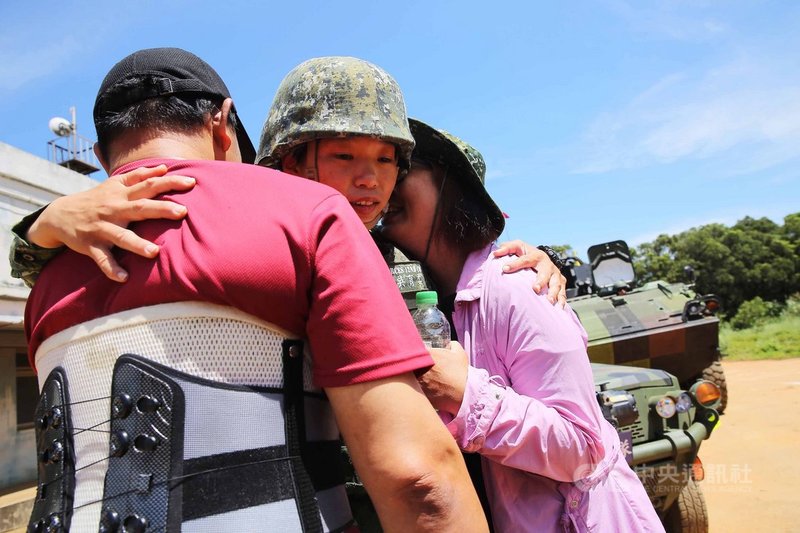 特一營特二連女性少尉輔導長吳育柔(中)19日進行行軍演練,訓後父母親突然現身打氣,3人相擁,成為最美風景。中央社記者游凱翔攝 109年6月19日