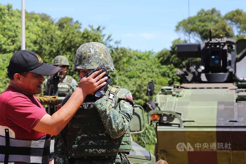 特戰女性少尉輔導長吳育柔(右)19日進行行軍演練,訓後父母親突然現身打氣,讓她喜極而泣,父親(左)替女兒擦臉。中央社記者游凱翔攝 109年6月19日