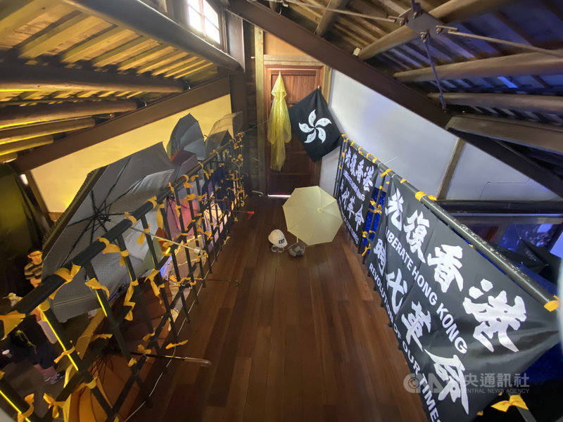 邊城青年籌劃主辦的「穿石 Surmount/香港騷動年代—抗志」展覽20日開幕,使用雨傘、防毒面具等道具,模擬去年香港「反送中」運動的街頭抗爭場景。中央社記者賴言曦攝 109年6月20日