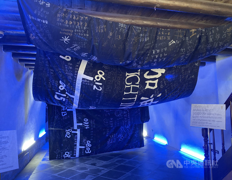 20日在「穿石 Surmount/香港騷動年代—抗志」中展出的「那年如水」布條,匯集香港18區民眾的心聲。邊城青年指出,布條以波浪狀的方式展現,並打上藍光,彰顯香港人在抗爭中Be Water」、如水一般的抗爭精神。中央社記者賴言曦攝 109年6月20日