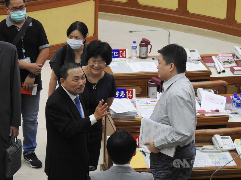 新北市議會24日進行市政總質詢,議員何博文(右)怒斥經發局提供錯誤資料誤導民代問政,新北市長侯友宜(前左)答詢時致歉,更在會後向何博文致意溝通。中央社記者王鴻國攝109年6月24日