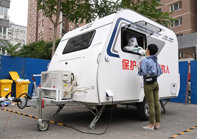 據中國官方發布,北京此波疫情已有256例確診,其中與新發地市場有關的病例有253例。圖為北京設置「防疫檢測移動艙」替民眾做武漢肺炎核酸檢測採樣。(中新社提供)