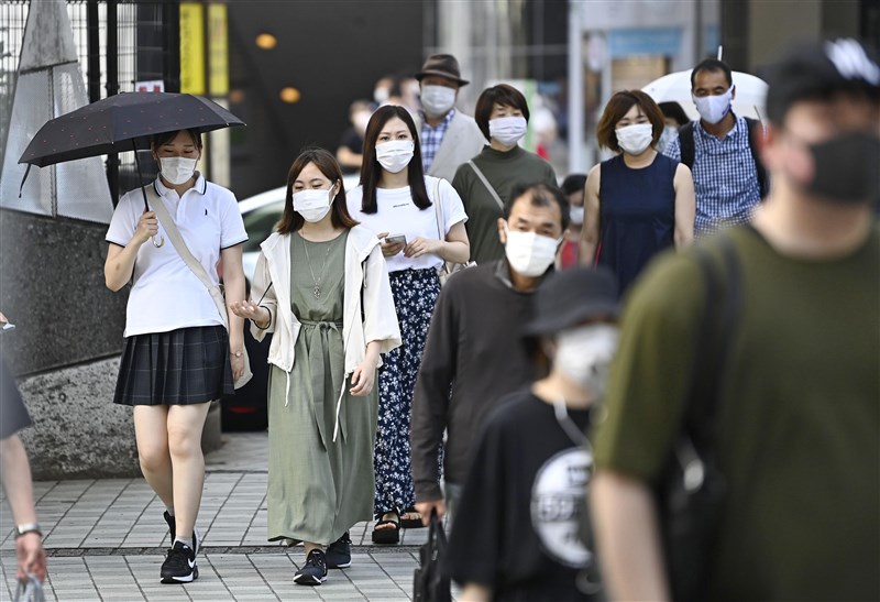 共同社報導,日本26日新增破百起武漢肺炎感染病例,為5月9日以來首見。圖為新宿車站前民眾戴口罩防疫。(共同社提供)