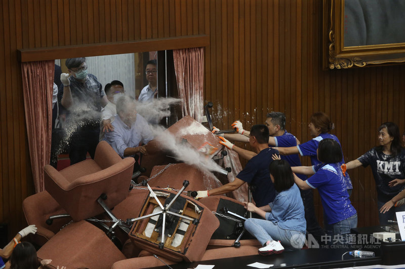 國民黨立委29日持續占領議場,原訂上午10時30分舉行談話會,民進黨立委約在上午11時10分排除主席台後方兩入口鐵鍊,開門進入議場,藍綠雙方發生推擠衝突,還有人潑灑白色粉末。中央社記者鄭傑文攝 109年6月29日
