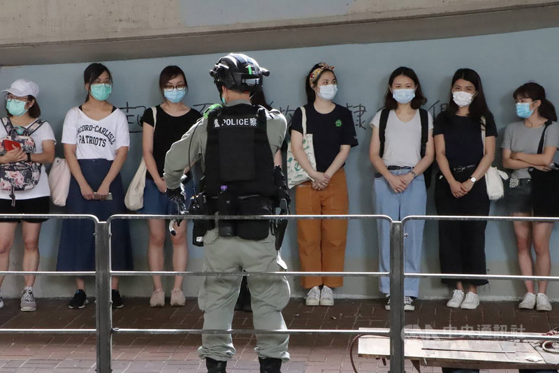 「港區國安法」6月30日深夜生效後,許多港人7月1日走上街頭遊行抗議。由於遊行未獲警方批准,港警在警告後,以涉嫌違反公安條例等逮捕了數十人。圖為警方在灣仔天樂里抓了20多人。中央社記者張謙香港攝 109年7月1日