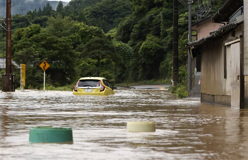 共同社報導,熊本縣與鹿兒島縣有7萬5000名居民被要求撤離家園,據報另有近100人受困。圖為熊本縣八代市4日車輛淹在泥濘水中。(共同社提供)