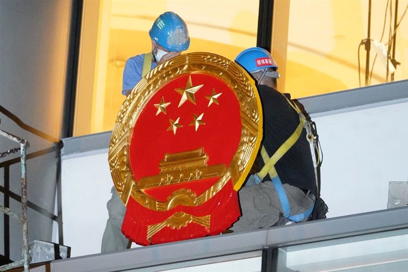 維景酒店在8日凌晨掛起中華人民共和國國徽,有工人運來大型水馬(充水式護欄)設置在路旁,大批機動部隊人員在場戒備,同時還出動警犬。(中新社提供)