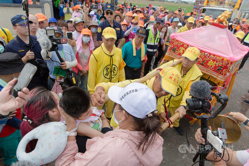 苗栗縣通霄鎮白沙屯拱天宮媽祖徒步進香之旅,9日自雲林北港朝天宮起駕回鑾,媽祖途中特別停轎,為鄭姓媽媽懷抱著的孩子賜福,場面令人感動。 (許瑋哲提供)中央社記者姜宜菁傳真 109年7月9日