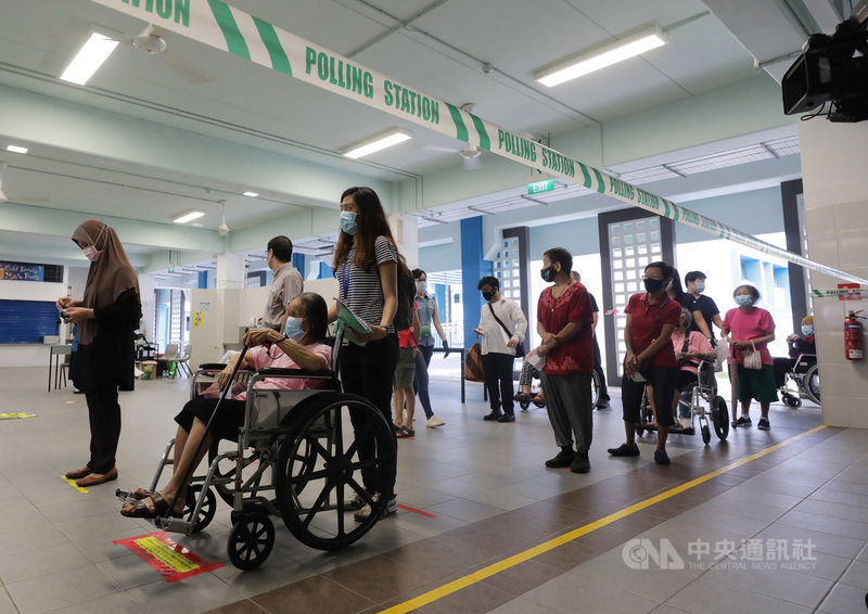 新加坡10日在疫情下舉行國會大選,選民保持社交安全距離,依序排隊進入德能中學投票站投票。中央社記者黃自強新加坡攝 109年7月10日