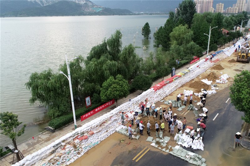 江西省鄱陽湖沿岸居民11日沿堤防堆放大量沙包,鄱陽湖口水位至12日下午4時直逼22.5公尺最高防洪水位。(中新社提供)