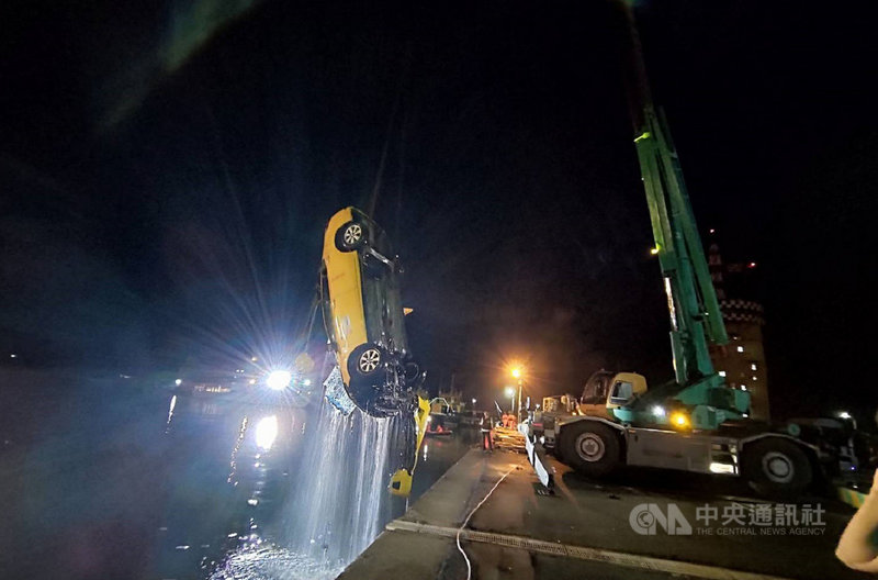 一輛計程車15日凌晨突然衝入台中港碼頭信號台旁落海，台中港務警察隊與海巡人員到場搜救，並出動重機具將計程車吊起。（海巡署中部分署提供）中央社記者蘇木春傳真　109年7月15日