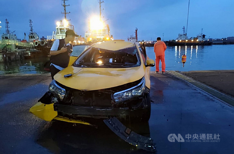 謝姓男子15日凌晨駕駛計程車載4名離岸風電區警戒船船員,疑因大雨視線不良,在台中港區碼頭墜海,台中港務消防隊獲報立即派遣人車前往救援,將車輛吊上岸後,由警方進行蒐證,釐清意外原因。(海巡署中部分署提供)中央社記者蘇木春傳真 109年7月15日