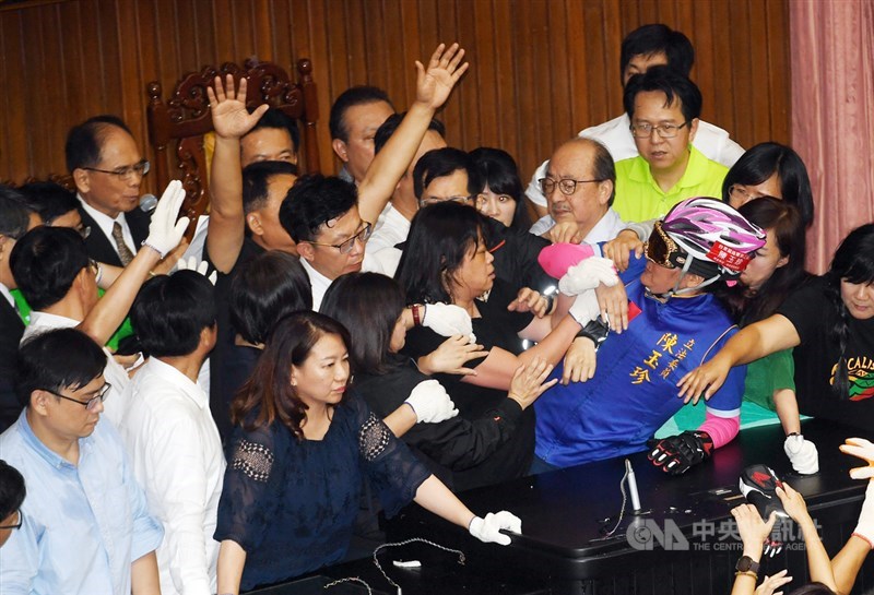 立法院臨時會本週處理監察院人事案,國民黨立委14日起占據立法院議場主席台至今,民進黨立委16日下午出動清場,將占據主席台的最後一位國民黨立委陳玉珍(戴安全帽者)拉走,立法院長游錫堃(後左)在混亂中進場宣布開會。中央社記者施宗暉攝 109年7月16日