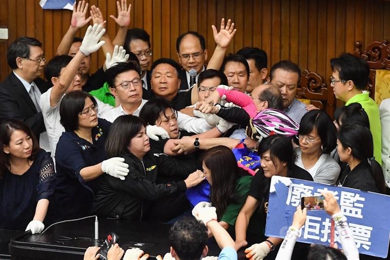 立法院長游錫堃(後中)16日下午在民進黨籍立委保護下,登上議場主席台宣布開會,經表決通過民進黨團提案,監察院人事同意權案提報院會,以無記名投票表決,現場相當混亂。中央社記者林俊耀攝 109年7月16日