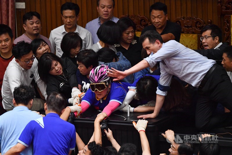 監察院人事案同意權投票在即,民進黨籍立委16日下午強勢清場,將占領主席台的國民黨籍立委逐一拉開,藍委陳玉珍(粉色安全帽者)緊貼台上不願離去。中央社記者林俊耀攝 109年7月16日