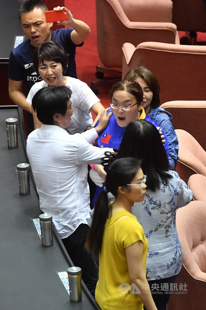 立法院16日下午在民進黨立委動員清場後恢復開會,國民黨立委陳玉珍(中右藍衣者)一度衝下台試圖阻止民進黨立委投票,但最終仍以出席57人中,贊成53人、反對4票,通過民進黨團提案將監察院人事同意權案,提報院會,以無記名投票表決。中央社記者林俊耀攝 109年7月16日