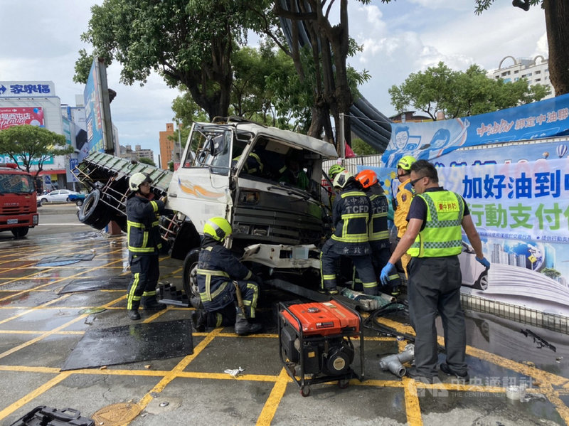 台中市廖姓男子20日駕駛大貨車，下坡時突然失控，先衝撞路旁一棵路樹，再撞上一家加油站招牌與圍牆側翻，廖男一度受困車內，消防人員到場將他救出送醫。（民眾提供）中央社記者蘇木春傳真　109年7月20日