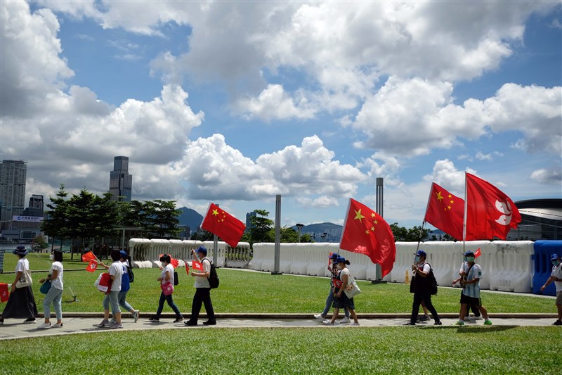 中國人大在國際反對聲浪之下通過港區國安法,箝制香港言論自由,英國20日宣布中止與香港的引渡協議。圖為香港親中民眾高舉中國與香港特區旗幟。(中新社)