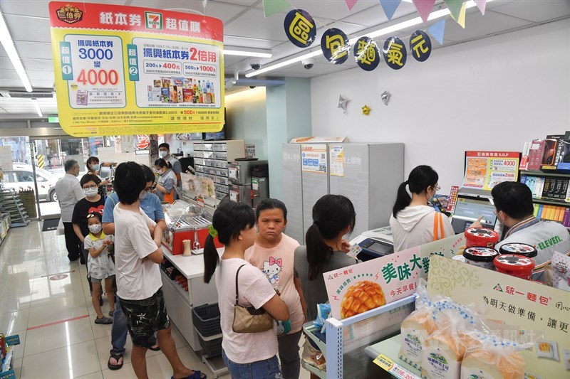 超商持續推出領券優惠,吸引到店民眾消費。圖為超商發放振興三倍券作業排隊人潮。(中央社檔案照片)