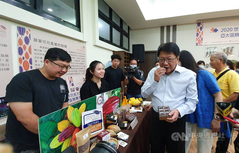 2020世界巧克力大獎(ICA)亞太區賽再度於屏東舉辦,屏東縣政府24日舉行記者會宣告啟動,並邀請在地可可業者到場展示,縣長潘孟安(前右)品嚐業者推薦的巧克力產品。中央社記者郭芷瑄攝 109年7月24日