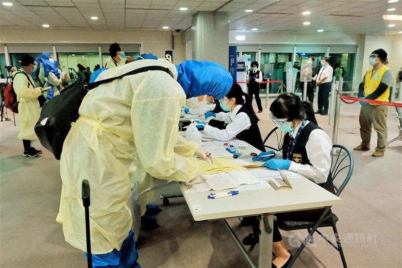 中央流行疫情指揮中心24日宣布新增3例武漢肺炎境外移入個案。圖為返台乘客入境後由國境疾管人員審核旅客健康聲明暨檢疫通知書內容。(中央社檔案照片)